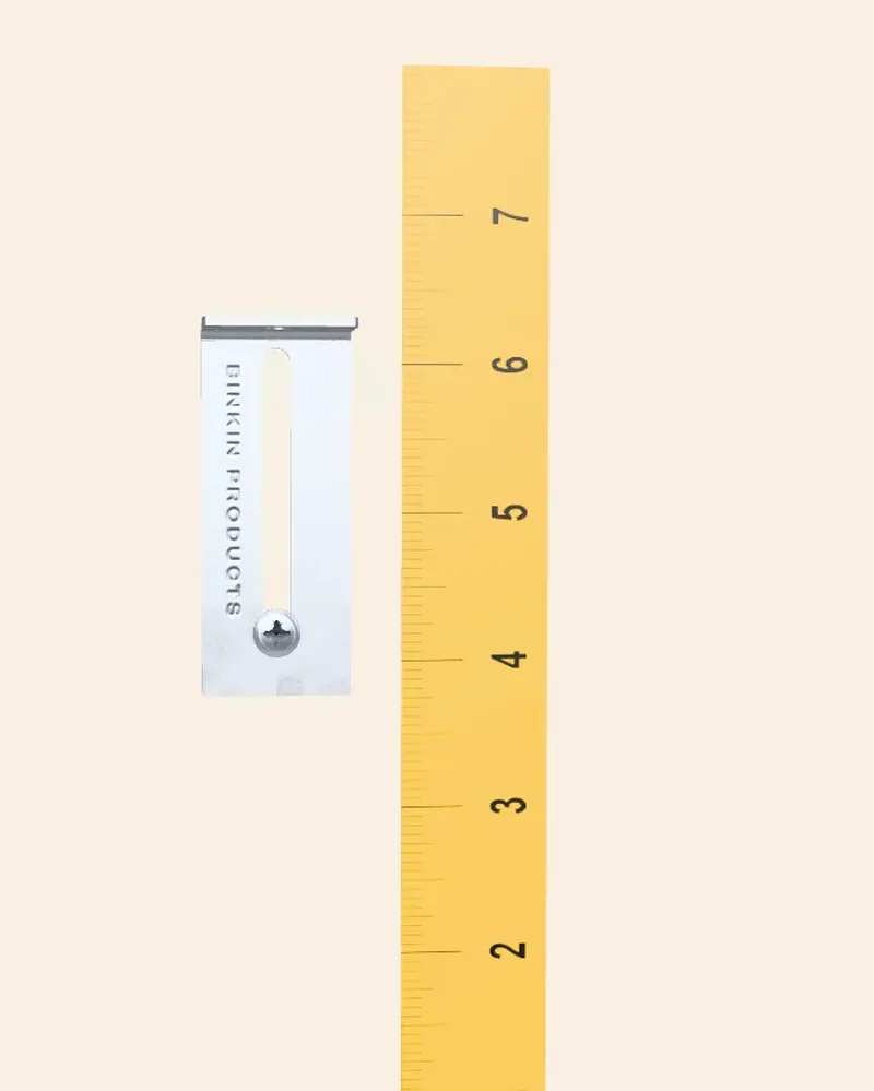 A 3D render of a BINKIN bracket beside a ruler, showing how far it travels along its slot