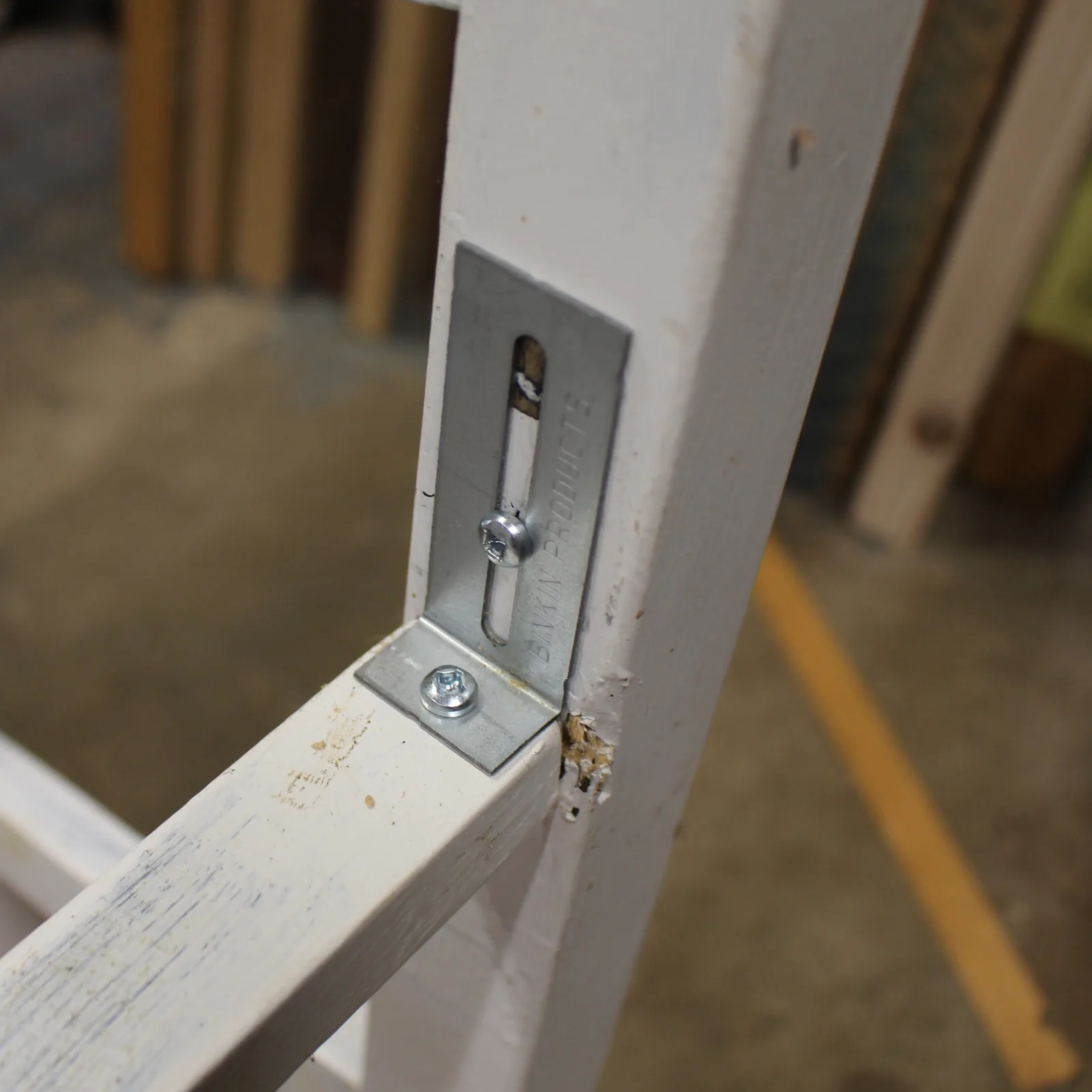 A BINKIN bracket holding a rail tight to the leg of a workshop stool
